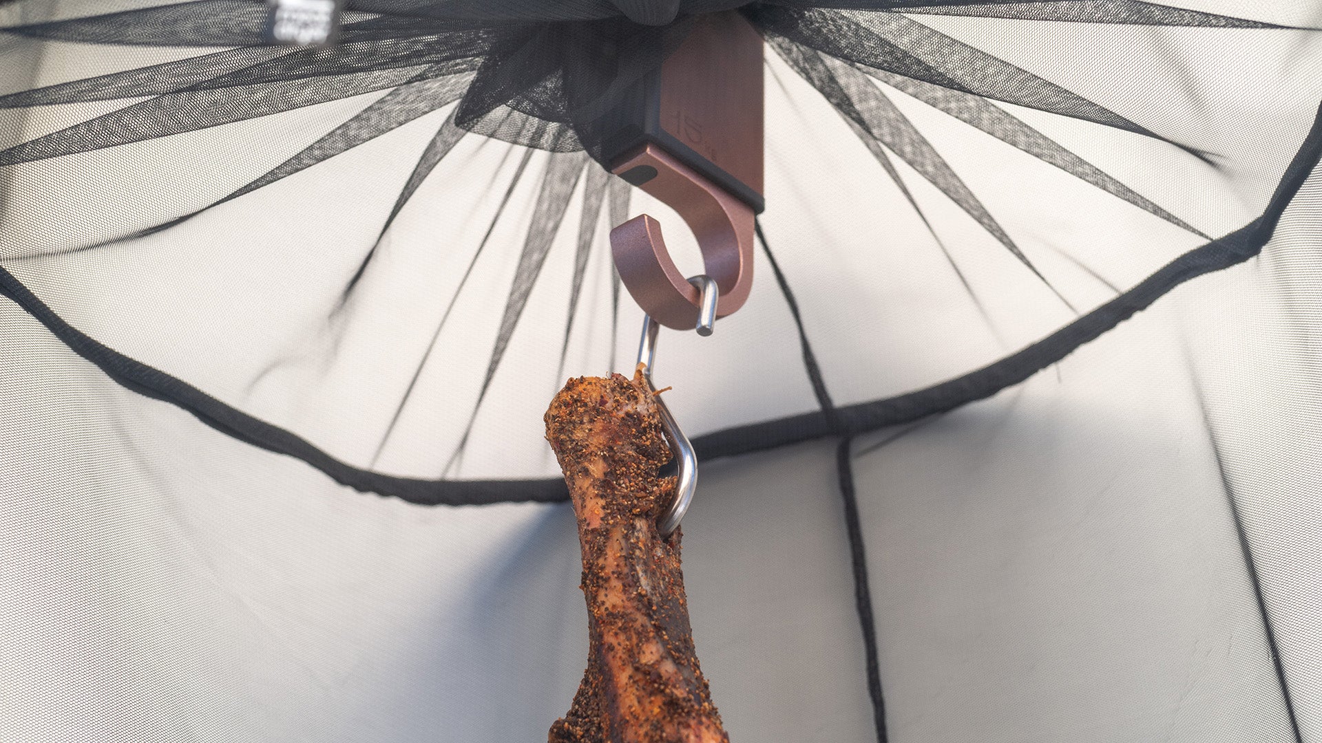 Protective net for flies and insects for meat, hanging on a meatdryer hook