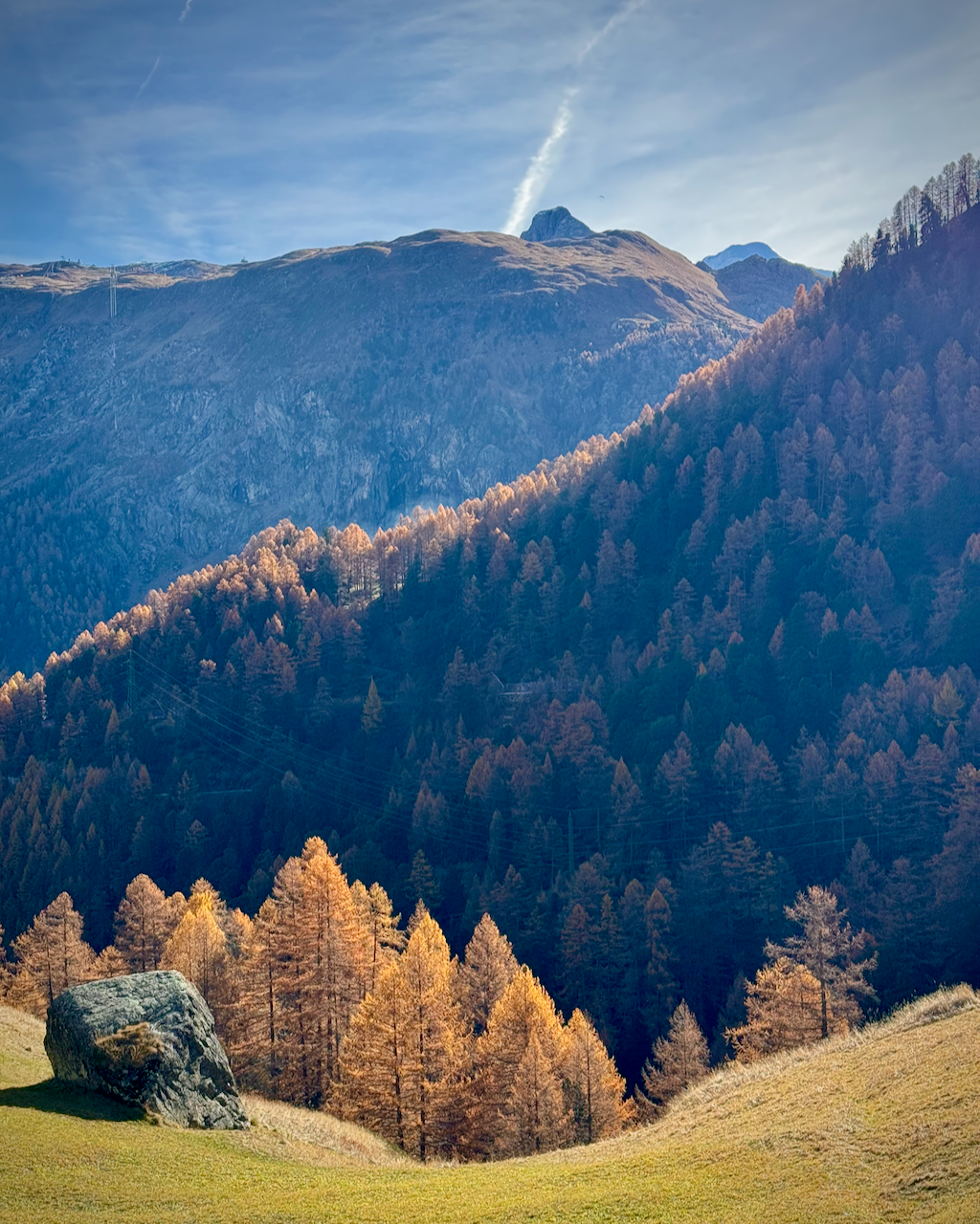 Mountain landscape in Zermatt with trees in autumn colors and a clear blue sky